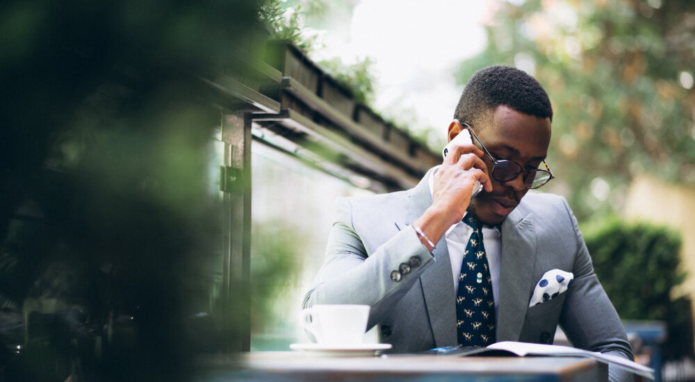 executive in grey suit holding phone