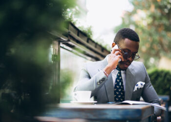 executive in grey suit holding phone